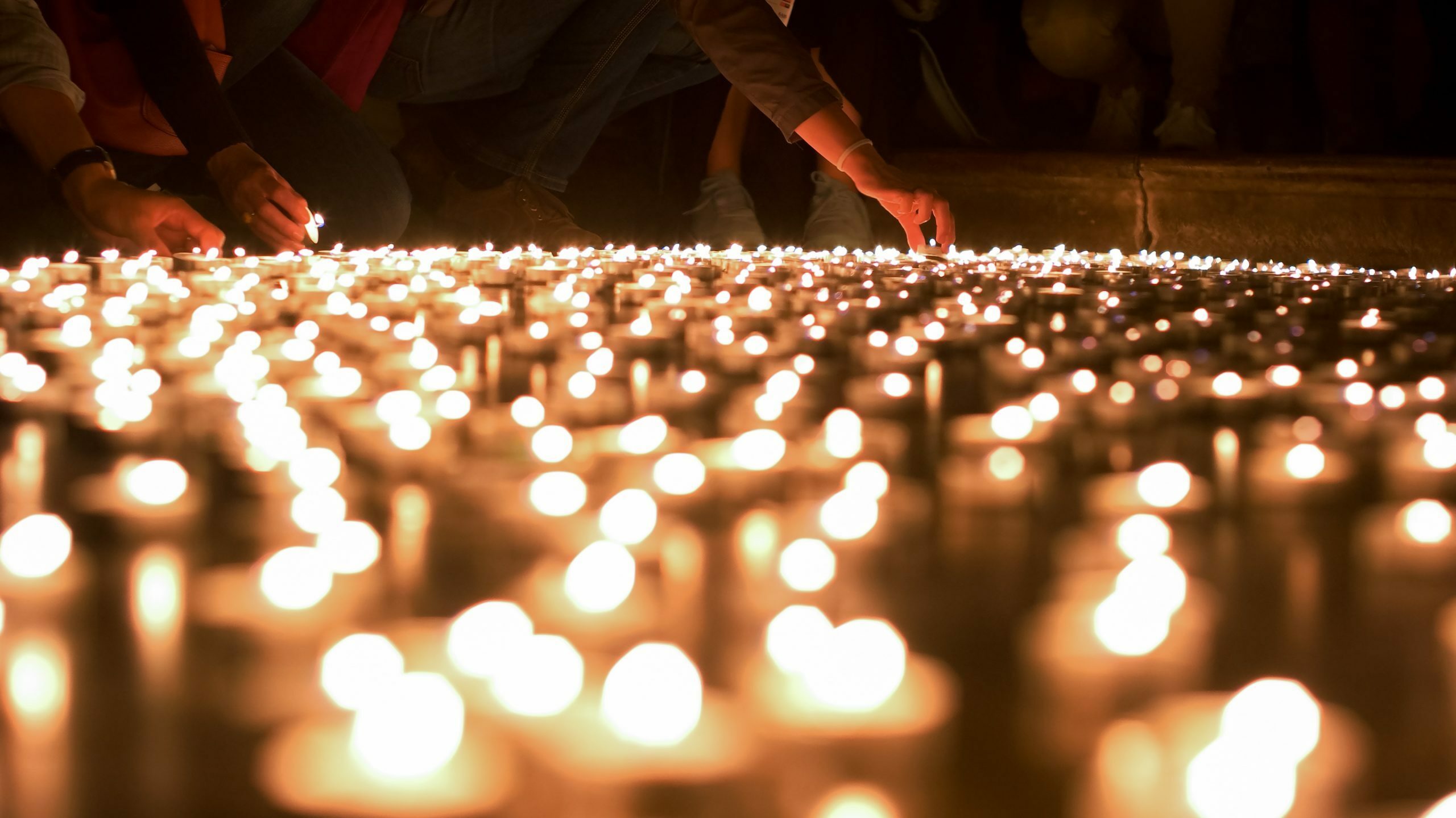 People Firing Up and Placing Candles to Other Ones